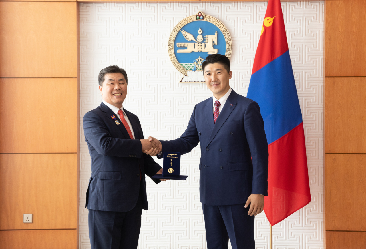 박요한(왼쪽) 대한항공 중국지역본부장이 대한항공 임직원을 대표해 오드바야르(E.Odbayar) 몽골 대통령실 외교정책담당 고문으로부터 메달을 수여받은 후 기념사진을 촬영하는 모습. [대한항공 제공]