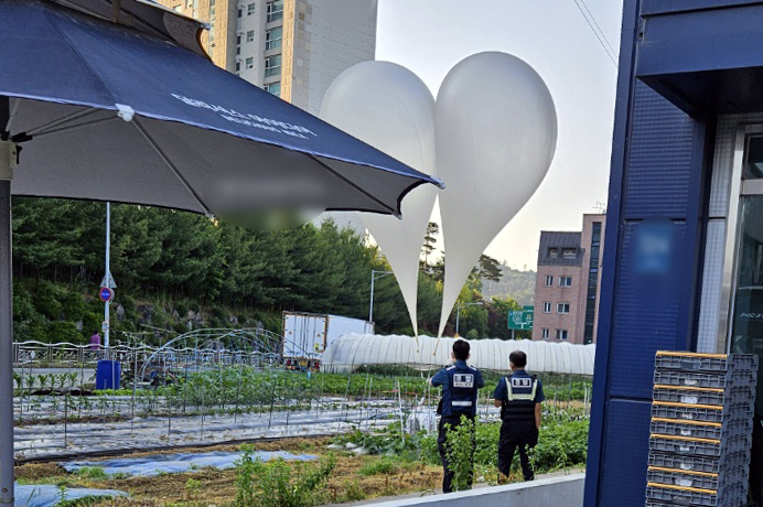 29일 오전 경기 용인시 처인구의 한 텃밭에서 북한이 날려 보낸 것으로 추정되는 풍선이 발견돼 군과 경찰이 내용물을 조사하고 있다. [연합]