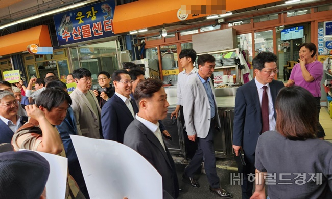 김영록 전남지사가 30일 웃장을 찾아 민생탐방을 가진 가운데 피켓 시위를 벌이는 군중 사이로 상기된 표정으로 지나고 있다. /박대성 기자.
