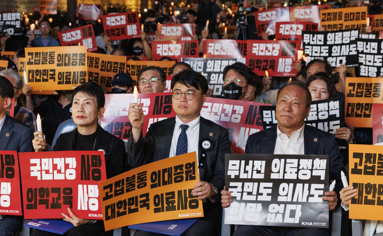 Lim Hyun-taek (center), the president of the Korean Medical Association, participates in a candlelight vigil protest held in front of Deoksugung Palance in Jung-gu, central Seoul, Friday night. (Yonhap)