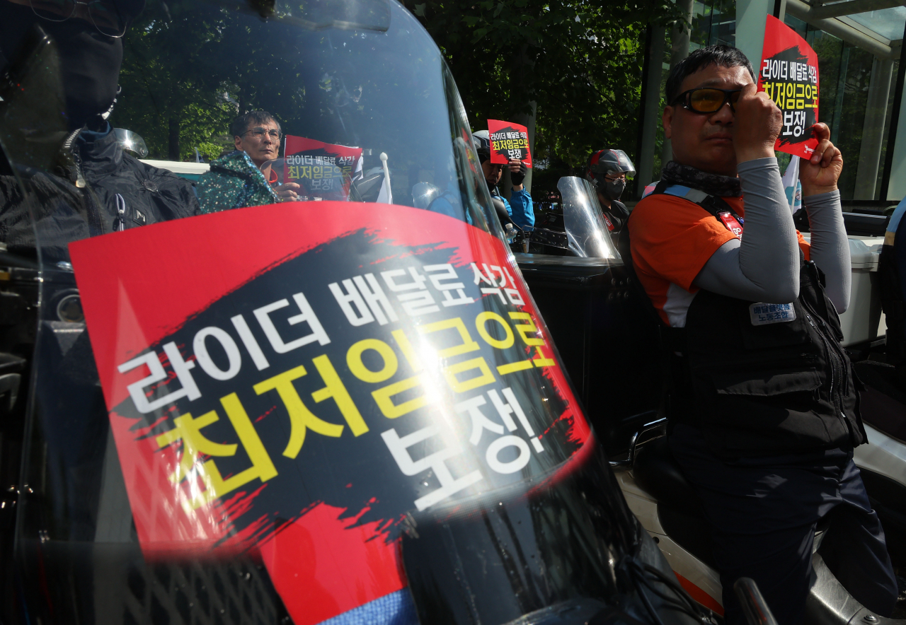 29일 서울 여의도 KB국민은행 앞에서 열린 라이더 최저임금 보장 요구 라이더 행진 집회에서 배달플랫폼노동조합원들이 구호를 외치고 있다. [연합]
