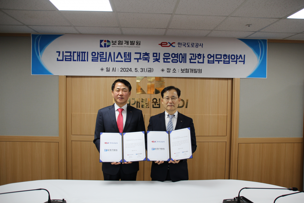 5월 31일 보험개발원에서 열린 ‘긴급대피 알림시스템 구축’ 업무협약 체결식에 참석한 설승환 한국도로공사 교통본부장(왼쪽)과 박진호 보험개발원 부원장이 기념촬영을 하고 있다. [한국도로공사]