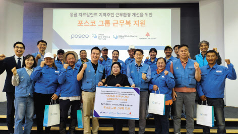 포스코 노사 관계자들이 몽골 주민들에게 구형 근무복을 전달하고 기념촬영을 하고 있다. [포스코 제공]