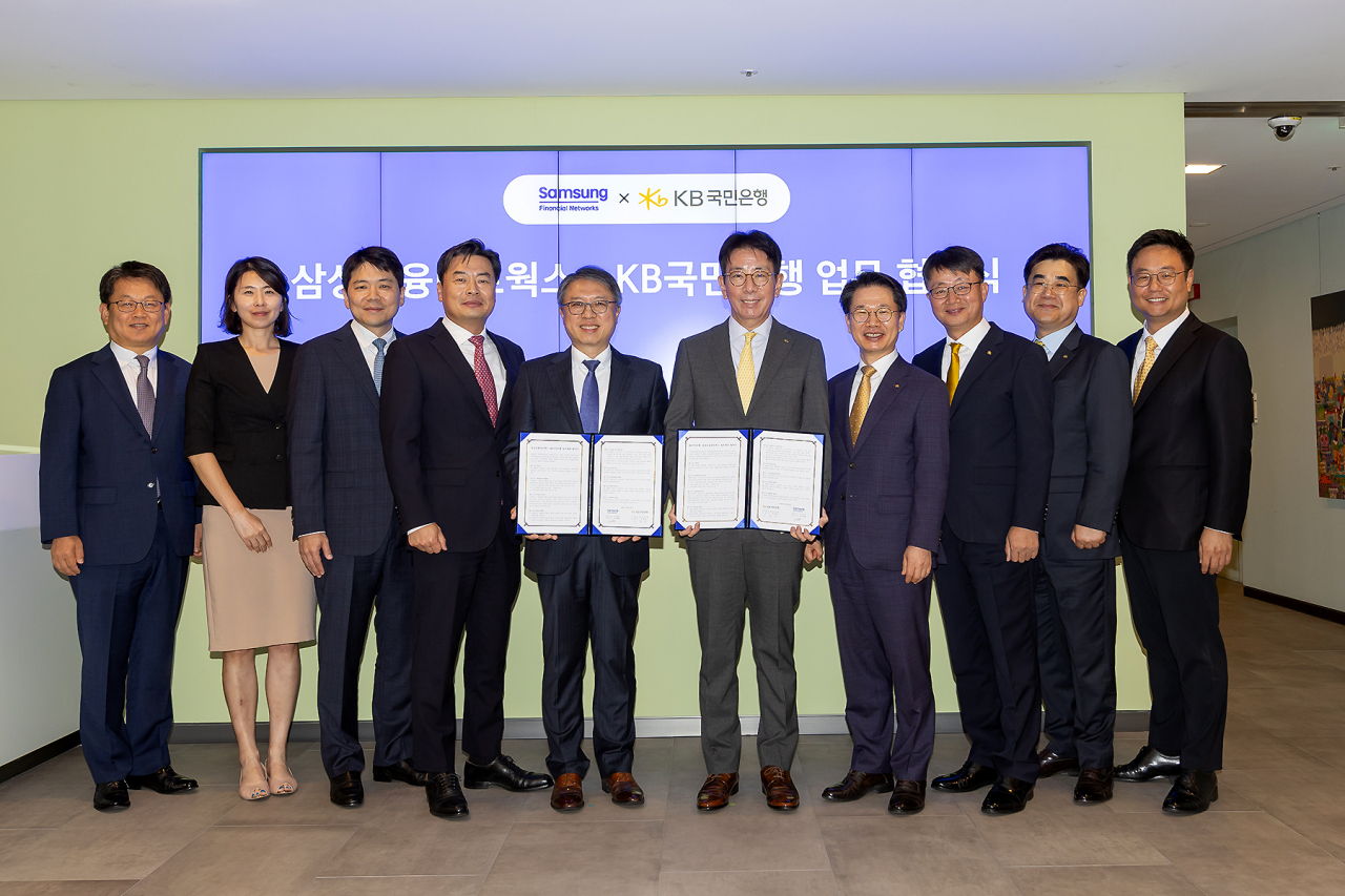 삼성금융네트웍스는 KB국민은행과 상호 협력을 위한 업무협약을 체결했다고 밝혔다. 삼성금융네트웍스를 대표해 김대환(왼쪽 다섯번째) 삼성카드 사장과 이재근(왼쪽 여섯번째) KB국민은행장, 삼성생명·화재·카드·증권 모니모 관련 업무 담당 임원, KB국민은행 관련 임원 등 관계자들이 기념사진을 촬영하고 있다. [삼성금융네트웍스 제공]