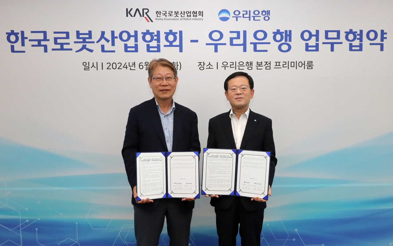 조병규(오른쪽) 우리은행장과 김진오 한국로봇산업협회장이 기념촬영을 하고 있다.[우리은행 제공]