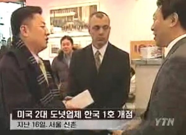 크리스피크림도넛의 국내 1호점인 신촌점 개장 당시 신동빈(오른쪽) 롯데 부회장이 밝게 웃으며 대화하고 있다. [YTN 뉴스 캡처]