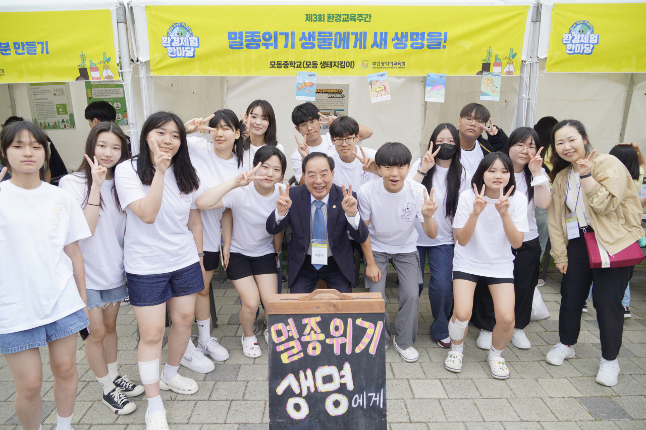 하윤수 부산시교육감(가운데)이 지난 8일 부산시민공원 다솜광장에서 열린 '제3회 바이바이 플라스틱 환경체험 한마당' 행사에서 학생들과 손가락으로 V를 그려보고 있다.. [사진=부산시교육청]