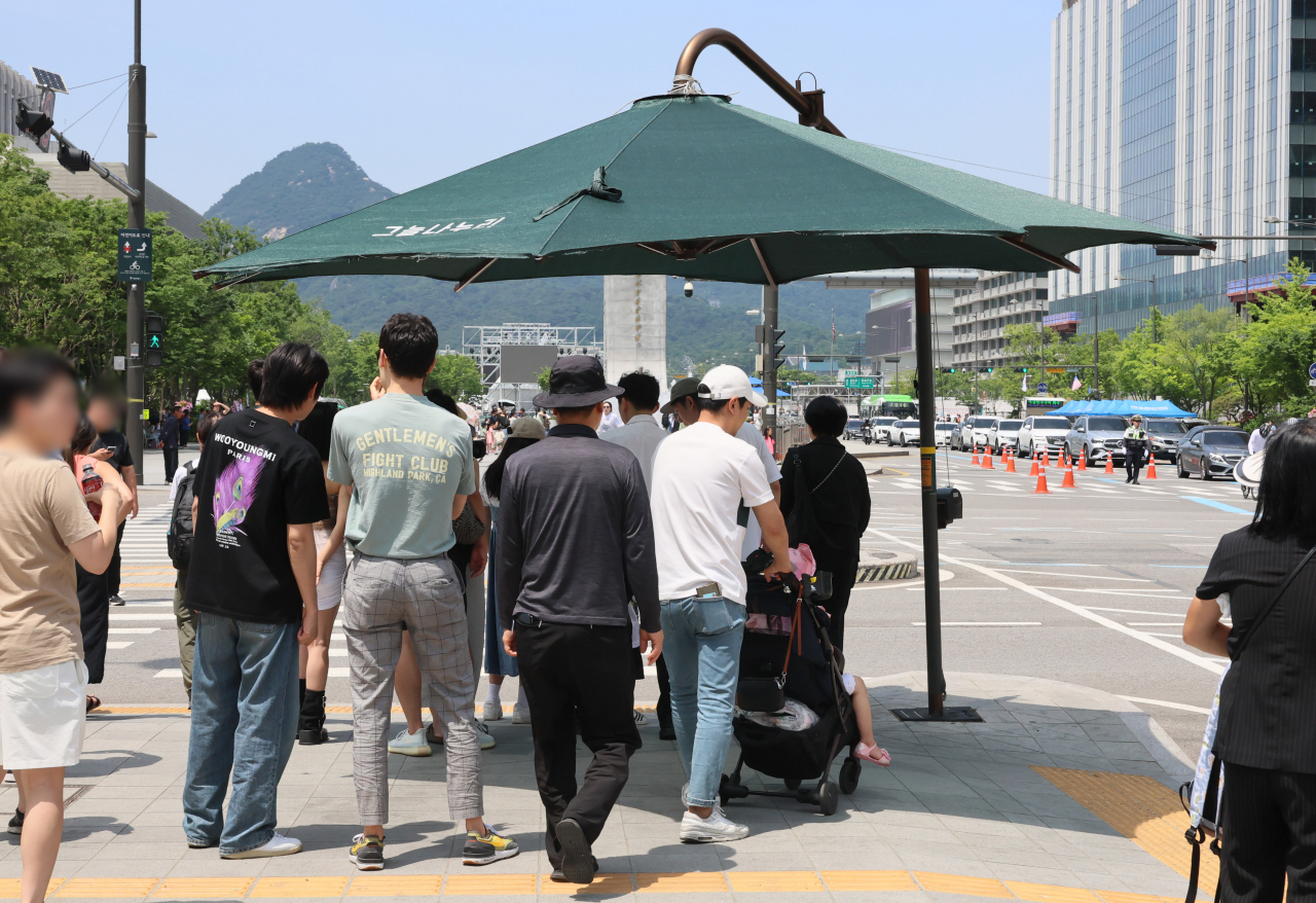 월요일인 10일 전국 대부분 지역의 낮 기온이 30도 이상으로 오르고 일부 지역에서는 체감온도가 31도를 넘겠다. 사진은 9일 서울 종로구 광화문 네거리에 설치된 그늘막 아래 시민들이 모여있는 모습. [연합]