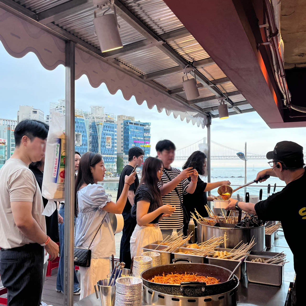 지난 9일 부산 광안리에 오픈한 ‘삼진포차’ 팝업스토어를 찾은 고객들이 어묵탕을 주문하고 있다. [사진=삼진어묵]