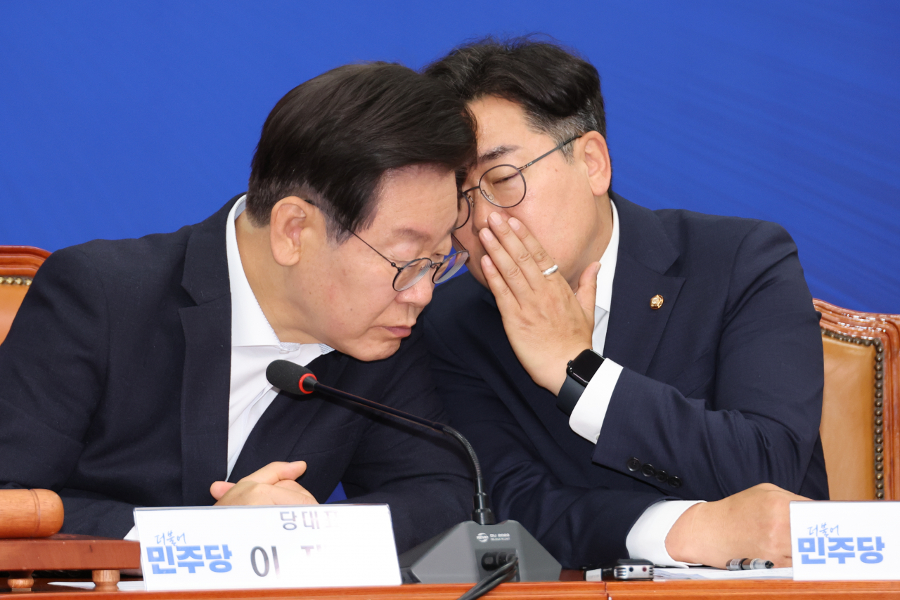 이재명(왼쪽) 더불어민주당 대표와 박찬대 원내대표가 12일 오전 서울 여의도 국회에서 열린 최고위원회의에서 귀엣말을 있다. [연합]