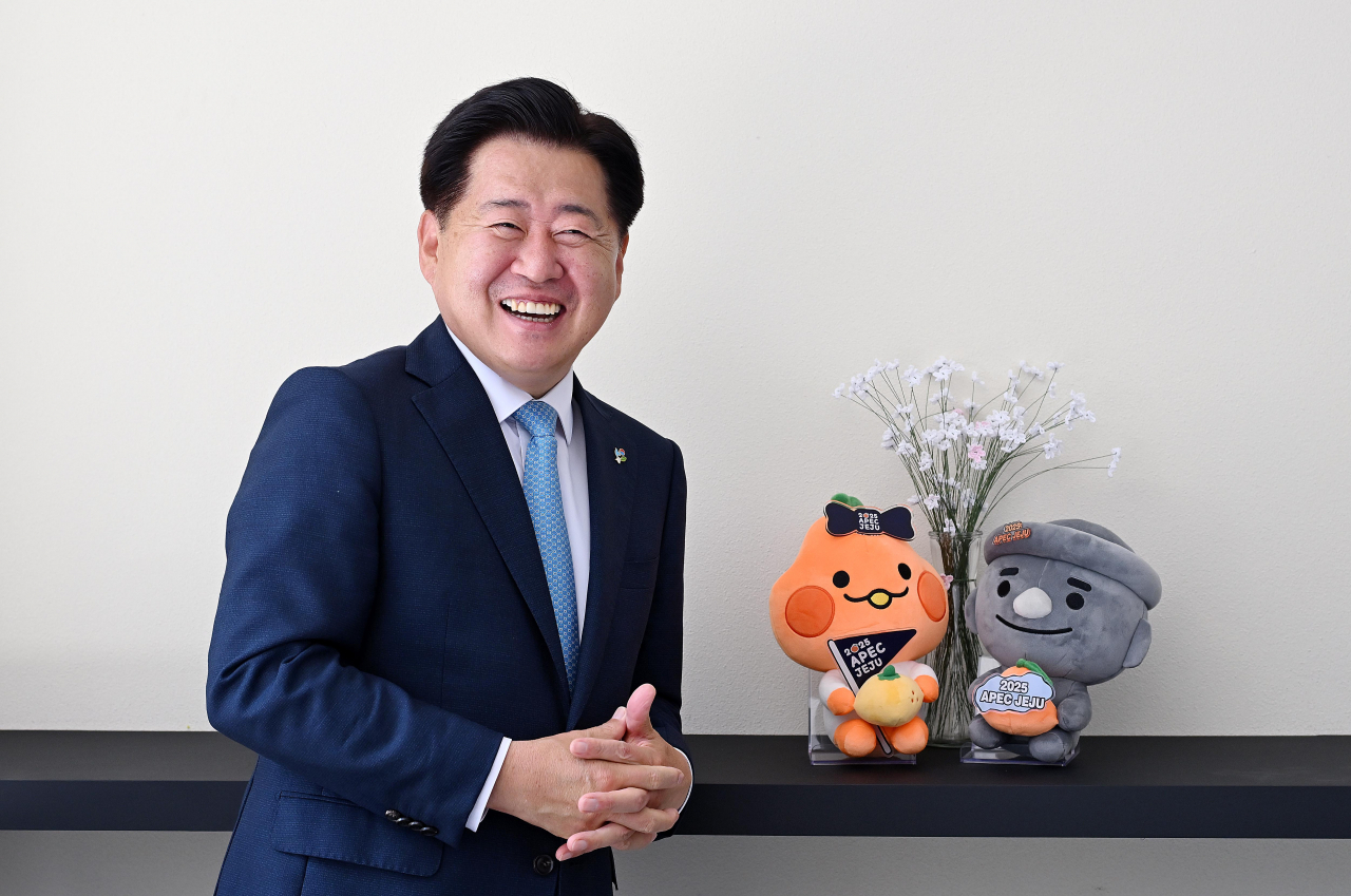 Oh Young-hoon, governor of Jeju Special Self-governing Province, poses with the island‘s mascots ahead of an interview with The Korea Herald in western Seoul on Tuesday. (Lee Sang-sub/The Korea Herald)