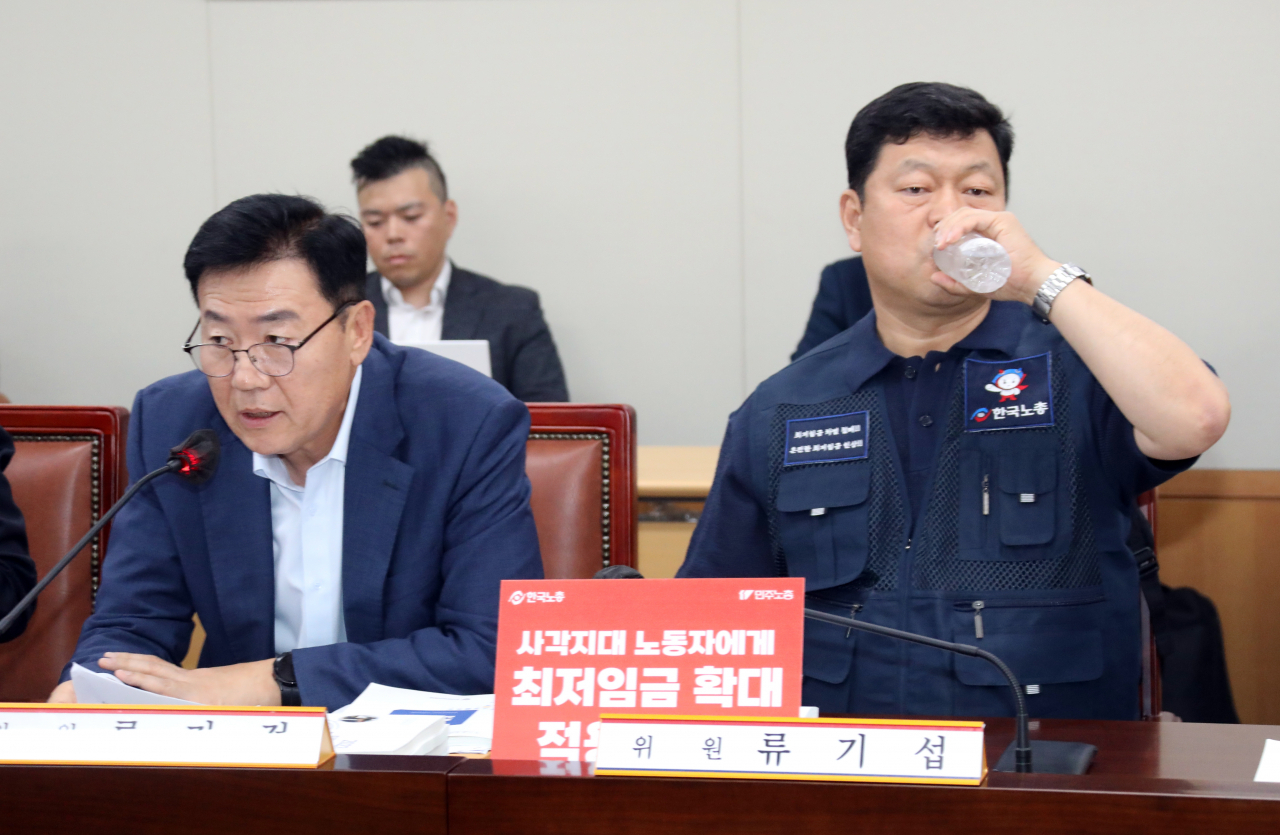 내년도 최저임금을 심의할 최저임금위원회 제4차 전원회의가 열린 13일 오후 정부세종청사 최저임금위원회에서 사용자위원 운영위원인 류기정 경총 전무(왼쪽)가 발언하는 동안 근로자위원 운영위원인 류기섭 한국노총 사무총장이 물을 마시며 목을 축이고 있다. [연합]