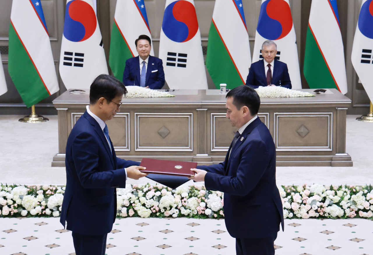 박상우 국토교통부 장관과 일홈 마흐카모프 우즈베키스탄 교통부 장관이 14일(현지시간) 우즈베키스탄 타슈켄트 대통령궁에서 열린 한·우즈베키스탄 협정 및 양해각서(MOU) 서명식에서 '교통 협력에 관한 기간 관 약정'에 서명 뒤 문서를 교환하고 있다. 이날 협정 및 MOU 서명식에는 윤석열 대통령과 샤브카트 미르지요예프 우즈베키스탄 대통령이 임석했다. [연합]