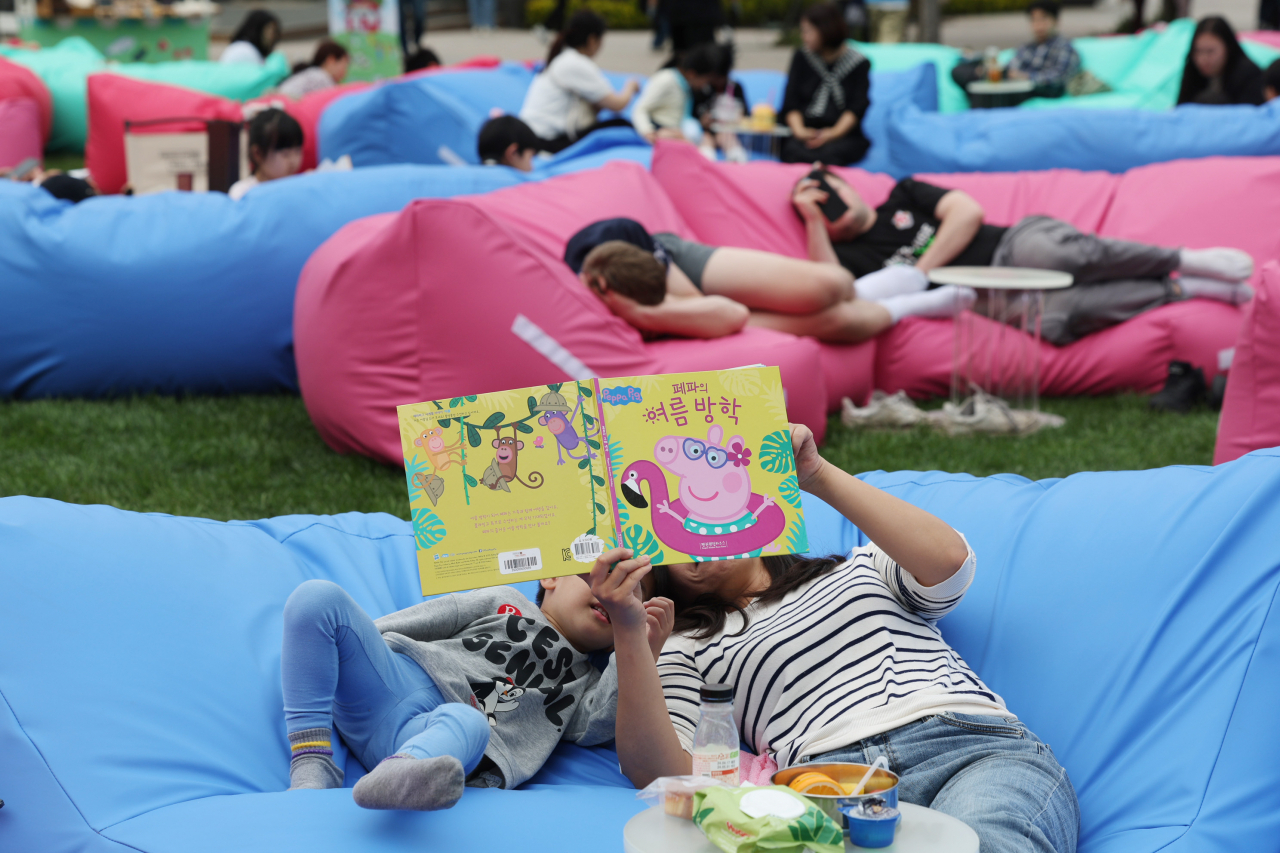 서울시청 앞 서울광장의 야외도서관인 ‘책읽는 서울광장’을 찾은 시민들이 독서하며 휴식을 즐기고 있다.[연합]