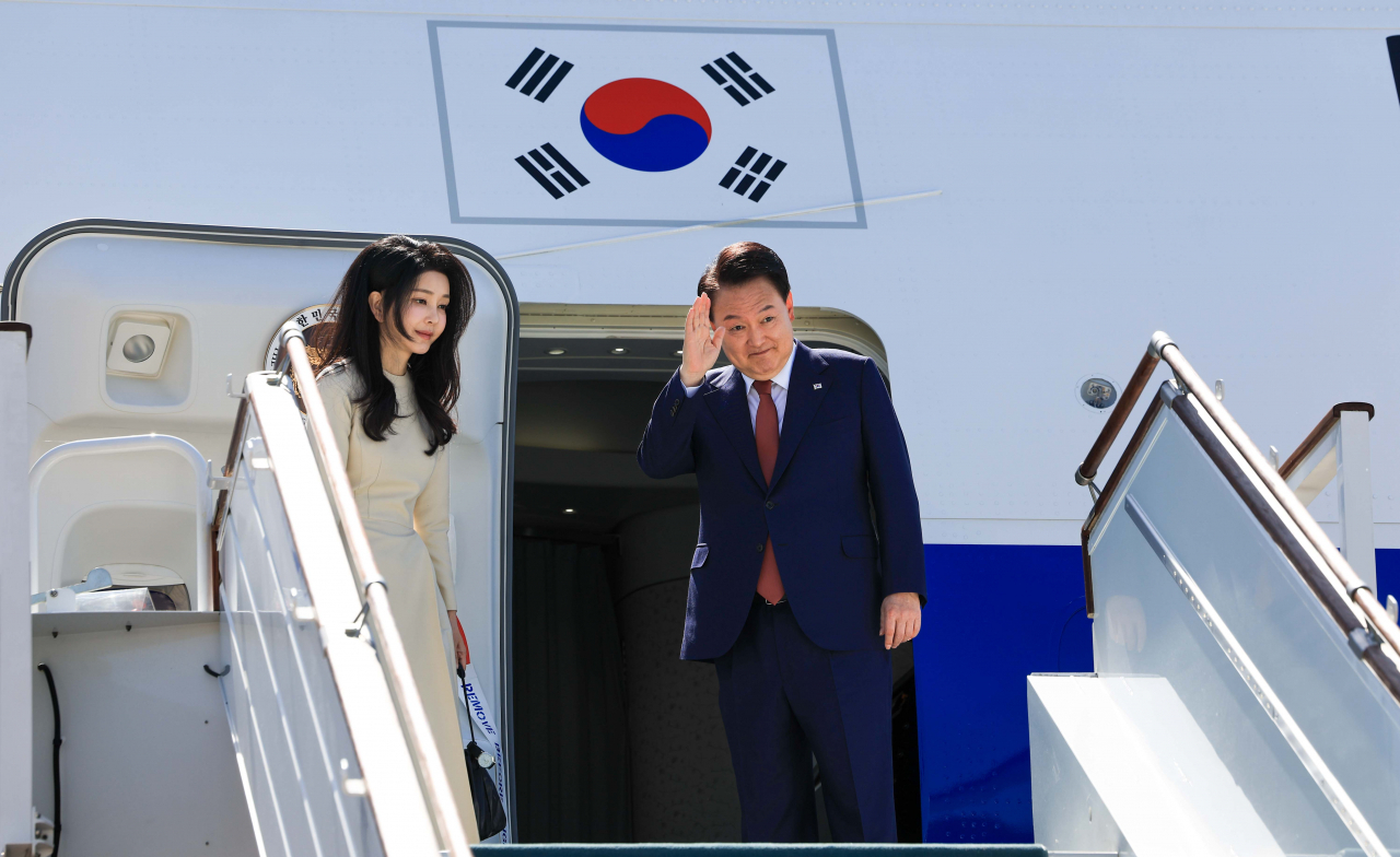 윤석열 대통령과 김건희 여사가 15일 오전(현지시간) 우즈베키스탄 타슈켄트 공항에서 유네스코 세계 문화유산인 고도시 사마르칸트로 향하며 전용기인 공군 1호기에 올라 인사하고 있다. [연합]