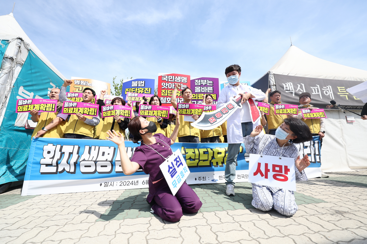 서울대병원 교수들이 전공의 사태 해결 등을 요구하며 무기한 휴진에 들어간 17일 오전 서울 여의도 국회 앞에서 전국의료산업노동조합연맹 관계자 등이 의사 휴진 철회를 촉구하며 퍼포먼스를 하고 있다. [연합]