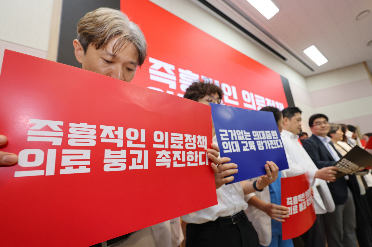 17일 오전 종로구 서울대학교 의과대학 융합관 양윤선홀에서 서울의대·서울대병원 교수협의회 비상대책위원회 주최 휴진 관련 집회가 열리는 가운데 의료진이 피켓을 들고 있다. 이날부터 서울대병원 교수들은 전공의 사태 해결 등을 요구하며 무기한 휴진에 들어간다. [연합]