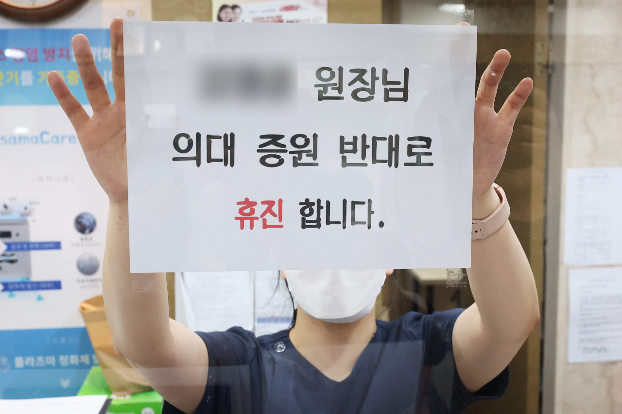 의료계 집단휴진이 시작된 가운데 한 의원이 휴진 안내문을 붙이고 있다. [연합]