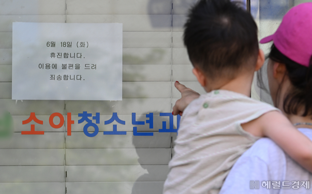 대한의사협회 주도로 18일 전국의 병원과 의원이 의대 증원 원점 재검토를 요구하며 휴진에 돌입했다. 이날 오전 서울 시내의 한 병원을 찾은 모자가 휴진 안내문을 살펴보고 있다. 임세준 기자
