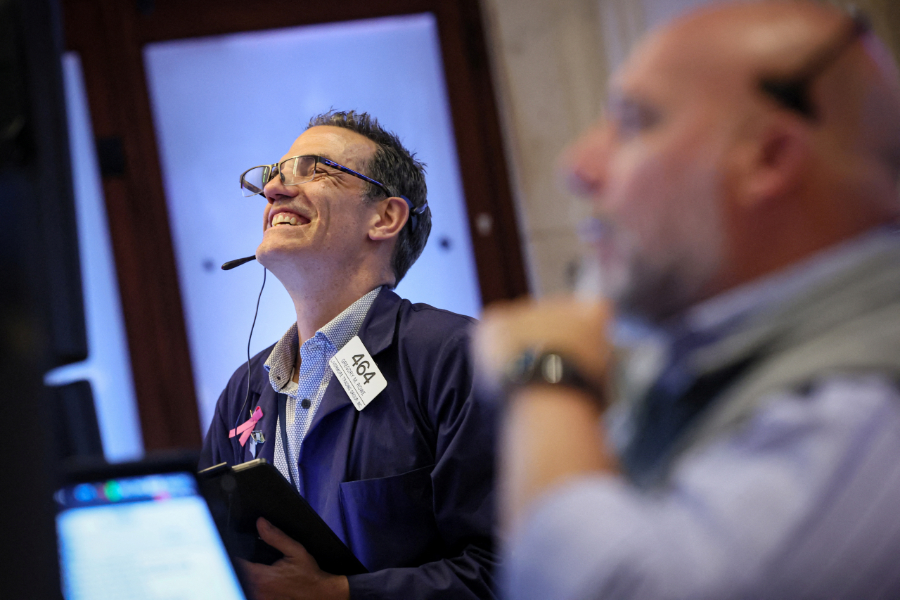 14일(현지시간) 미국 뉴욕에 있는 뉴욕증권거래소(NYSE)에서 직원들이 환호하고 있다. [로이터]