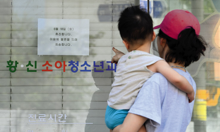 대한의사협회 주도로 18일 전국의 병·의원이 의대 증원 원점 재검토를 요구하며 휴진에 돌입했다. 이날 오전 서울 시내의 한 의원을 찾은 모자가 휴진 안내문을 살펴보고 있다. 임세준 기자