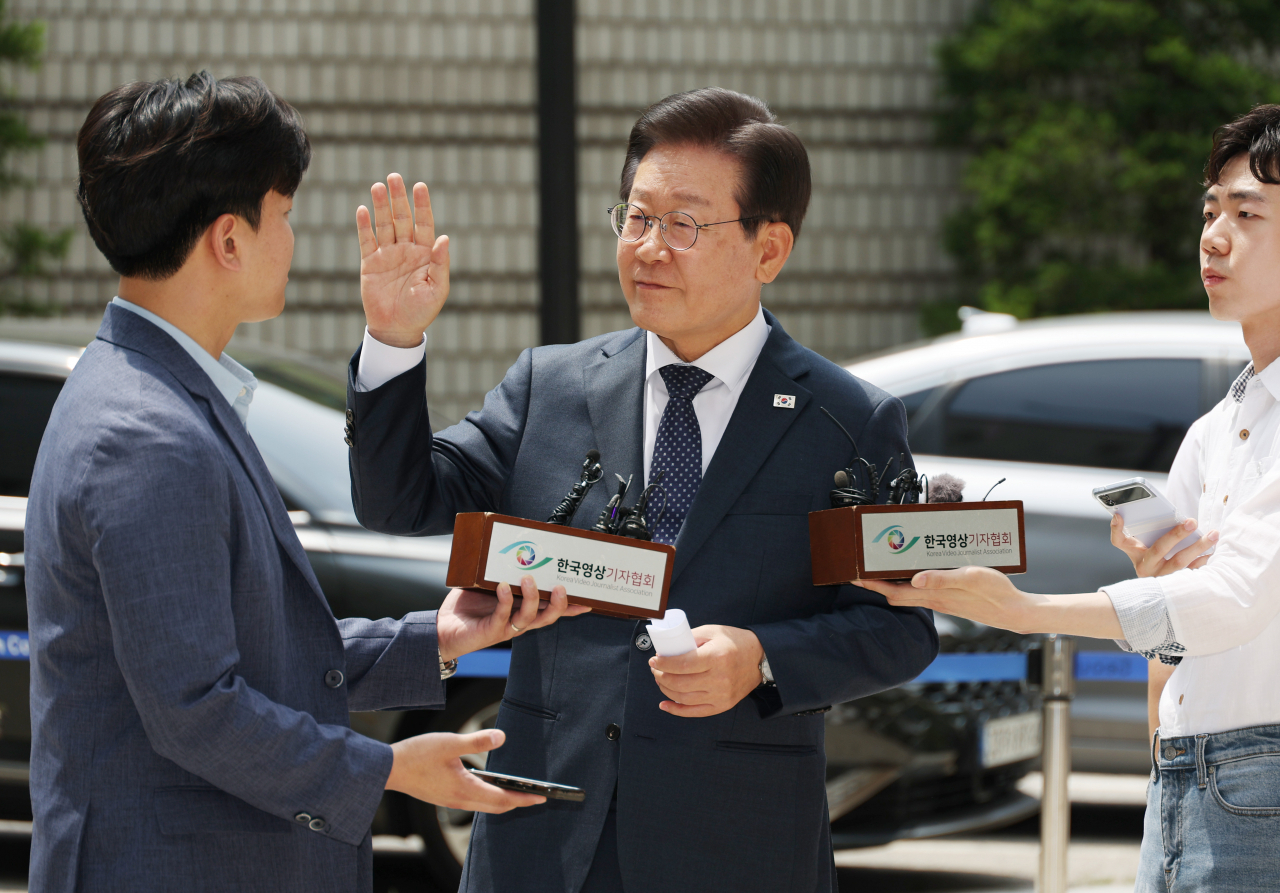 더불어민주당 이재명 대표가 14일 서울 서초동 서울중앙지법에서 열리는 공직선거법 관련 재판에 출석하기에 앞서 취재진 앞에서 입장을 말하던 중 사람들을 향해 조용히 해줄 것을 요청하고 있다. [연합]
