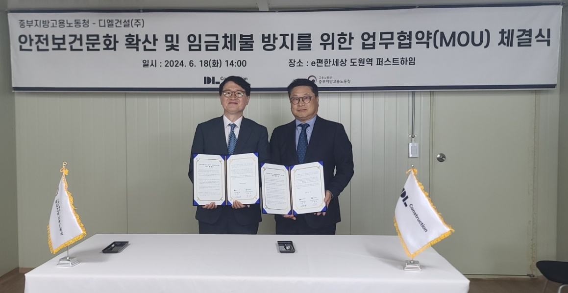 지난 18일 ‘e편한세상 도원역 퍼스트하임’ 신축공사 현장에서 진행된 ‘안전문화 확산 및 건설근로자 임금체불 방지를 위한 업무 협약(MOU) 체결식’ 후 민길수 고용노동부 중부지방고용노동청장(왼쪽)과 이동근 DL건설 CSO가 기념 촬영하고 있다. [DL건설]