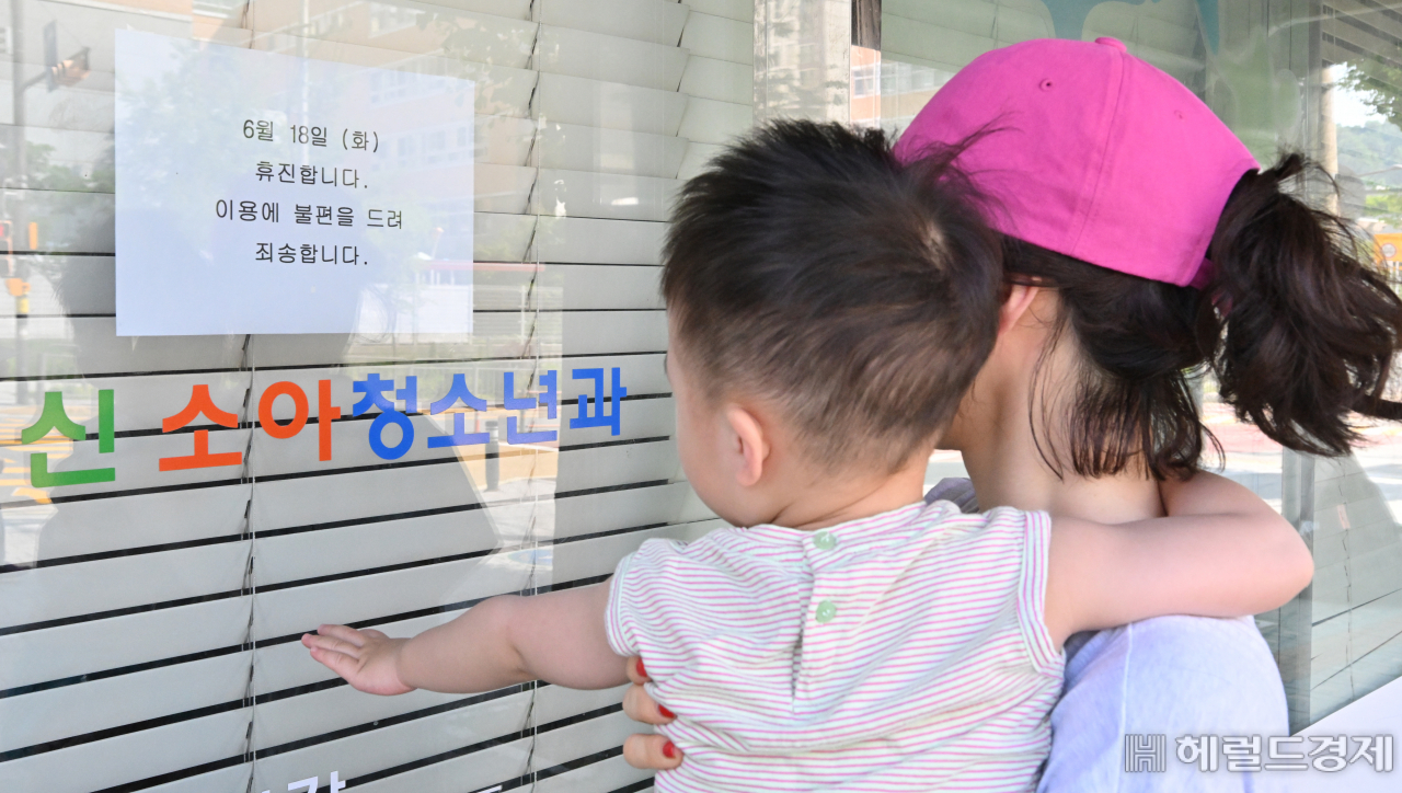 대한의사협회 주도로 18일 전국의 병원과 의원이 의대 증원 원점 재검토를 요구하며 휴진에 돌입했다. 이날 오전 서울 시내의 한 병원을 찾은 모자가 휴진 안내문을 살펴보고 있다. 임세준 기자