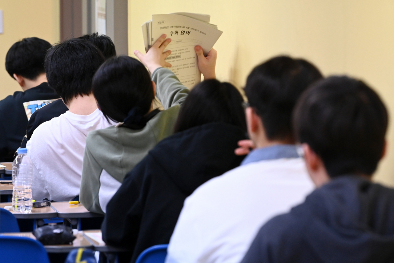 4일 오전 서울 양천구 목동종로학원에서 수험생들이 2025학년도 대학수학능력시험 평가원 6월 모의고사를 위해 시험지를 건네받고 있다. [연합]
