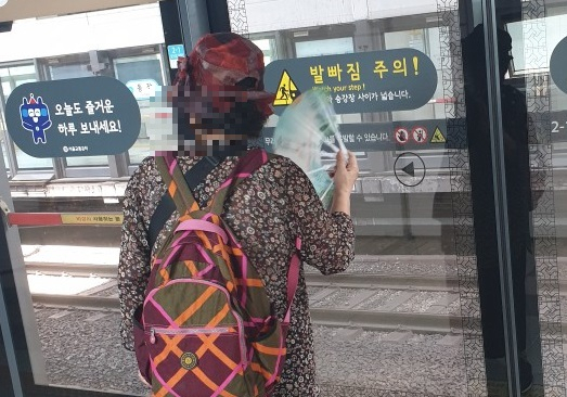 서울의 한 지하철역에서 한 시민이 더위를 달래러 부채질을 하고 있다.