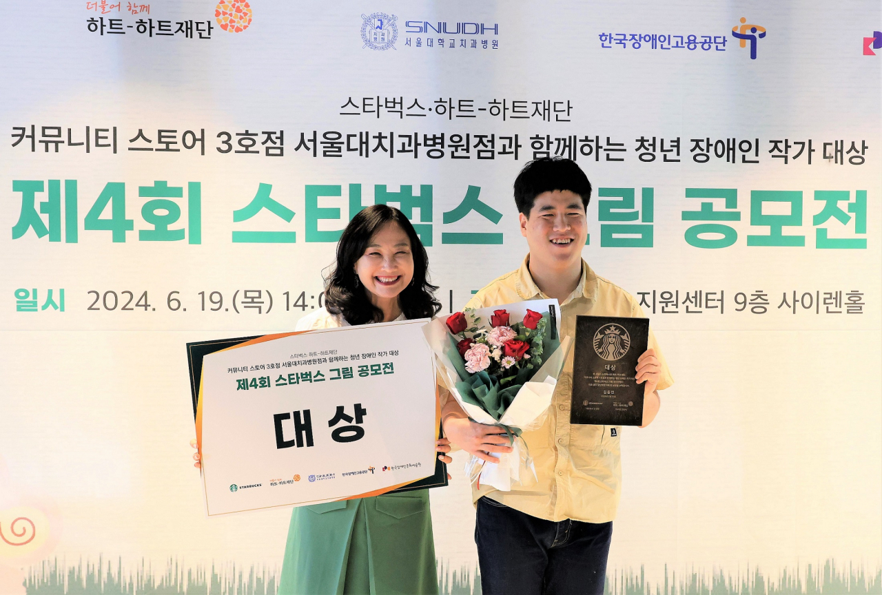 제4회 스타벅스 그림 공모전에서 대상을 수상한 김동연(오른쪽) 작가가 장수아 스타벅스 인사담당 상무와 기념 사진을 촬영하고 있다. [스타벅스 코리아 제공]