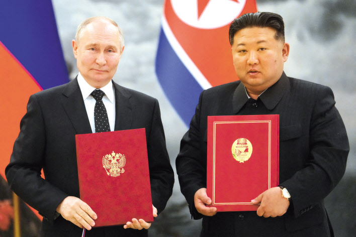 김정은 북한 국무위원장과 블라디미르 푸틴 러시아 대통령이 19일 북한 평양 금수산 영빈관에서 ‘포괄적 전략 동반자 협정’을 체결한 후 협정서를 들고 기념 촬영하고 있다. [로이터]