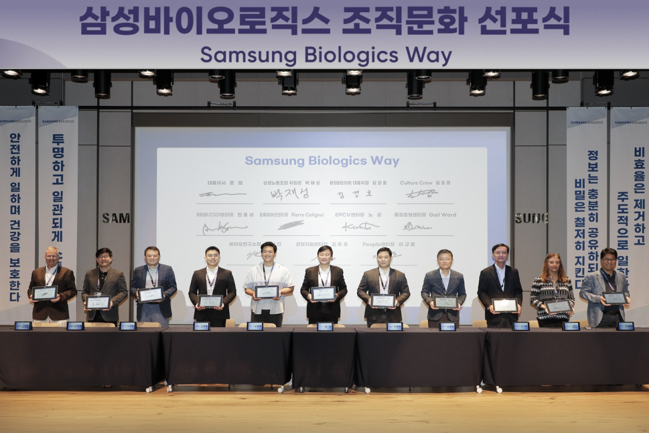 삼성바이오로직스는 20일 조직문화 선포식을 열고 글로벌한 조직문화를 만들어 나가는 데 노사가 한뜻으로 협력할 것을 다짐했다. 삼성바이오로직스 존 림 대표(사진 가운데) 및 임원, 직원 대표들이 함께 서약서 작성 후 기념촬영을 하고 있는 모습. 삼성바이오로직스 제공