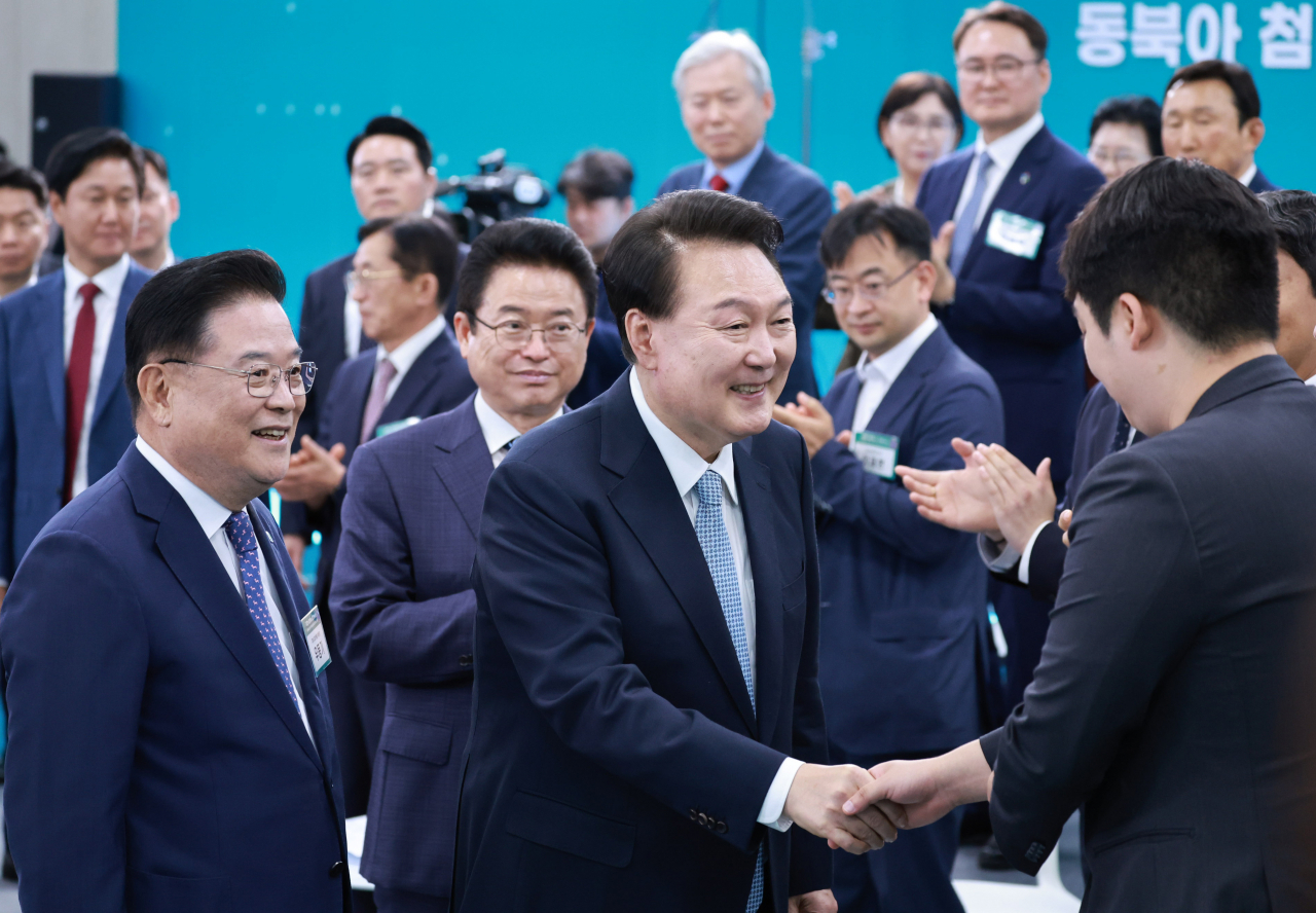 윤석열 대통령이 20일 경북 경산시 영남대 경산캠퍼스 천마아트센터에서 '동북아 첨단 제조혁신허브, 경북'을 주제로 열린 스물여섯 번째 '국민과 함께하는 민생토론회'에 입장하며 참석자와 악수하고 있다. [연합]
