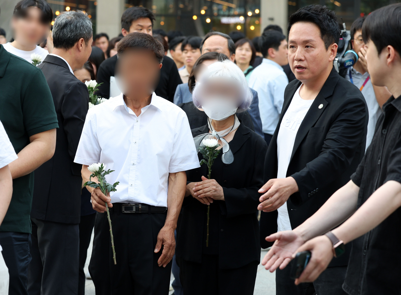 19일 오후 서울 용산역 광장에 마련된 군기훈련(얼차려)을 받다 사망한 육군 12사단 신병교육대 박 훈련병 시민 추모 분향소에서 박 훈련병 부모가 헌화하기 위해 이동하고 있다. 오른쪽은 임태훈 군인권센터 소장. [뉴시스]
