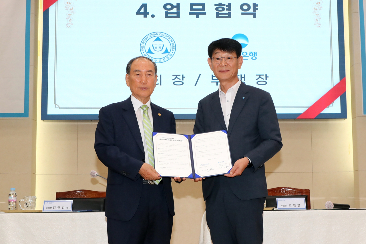 21일 서초구 방배동 대한예수교장로회 백석총회 본부에서 열린 업무협약식에 참석한 조병열(오른쪽) 우리은행 연금사업그룹장과 김진범(왼쪽) 대한예수교장로회 백석촉회장이 기념촬영을 하고 있다.[우리은행 제공]