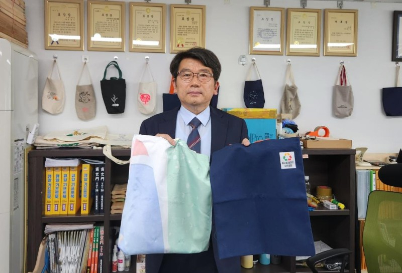 인천 사회적기업 ㈜쇠뿔 최현모 대표이사가 특허 출원으로 버려진 폐현수막을 이용해 제작한 에코백을 들어 보이고 있다.