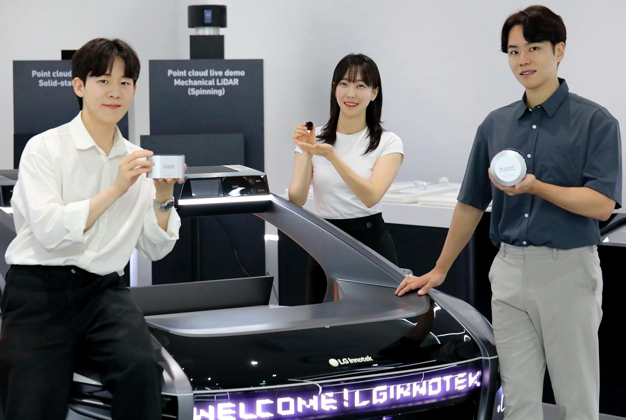 LG이노텍 임직원들이 차량 센싱 솔루션 핵심 부품인 ‘고성능 LiDAR’(왼쪽·오른쪽) 및 ‘고성능 히팅 카메라 모듈’(가운데)을 선보이고 있다. [LG이노텍 제공]