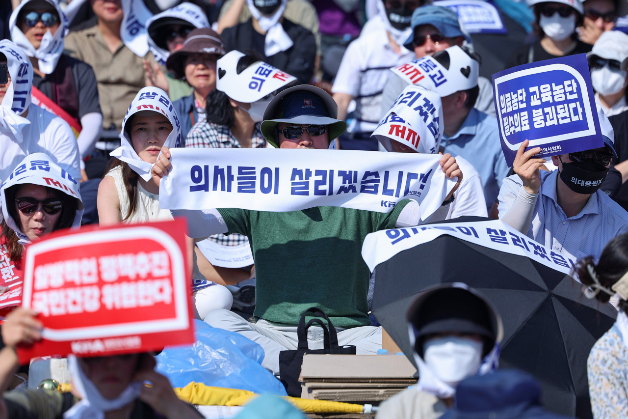 대한의사협회(의협)의 주도로 개원의와 일부 의대 교수들이 집단휴진에 나선 18일 오후 서울 영등포구 여의대로에서 열린 전국 의사 총궐기대회에서 참가자들이 구호를 외치고 있다. [연합]