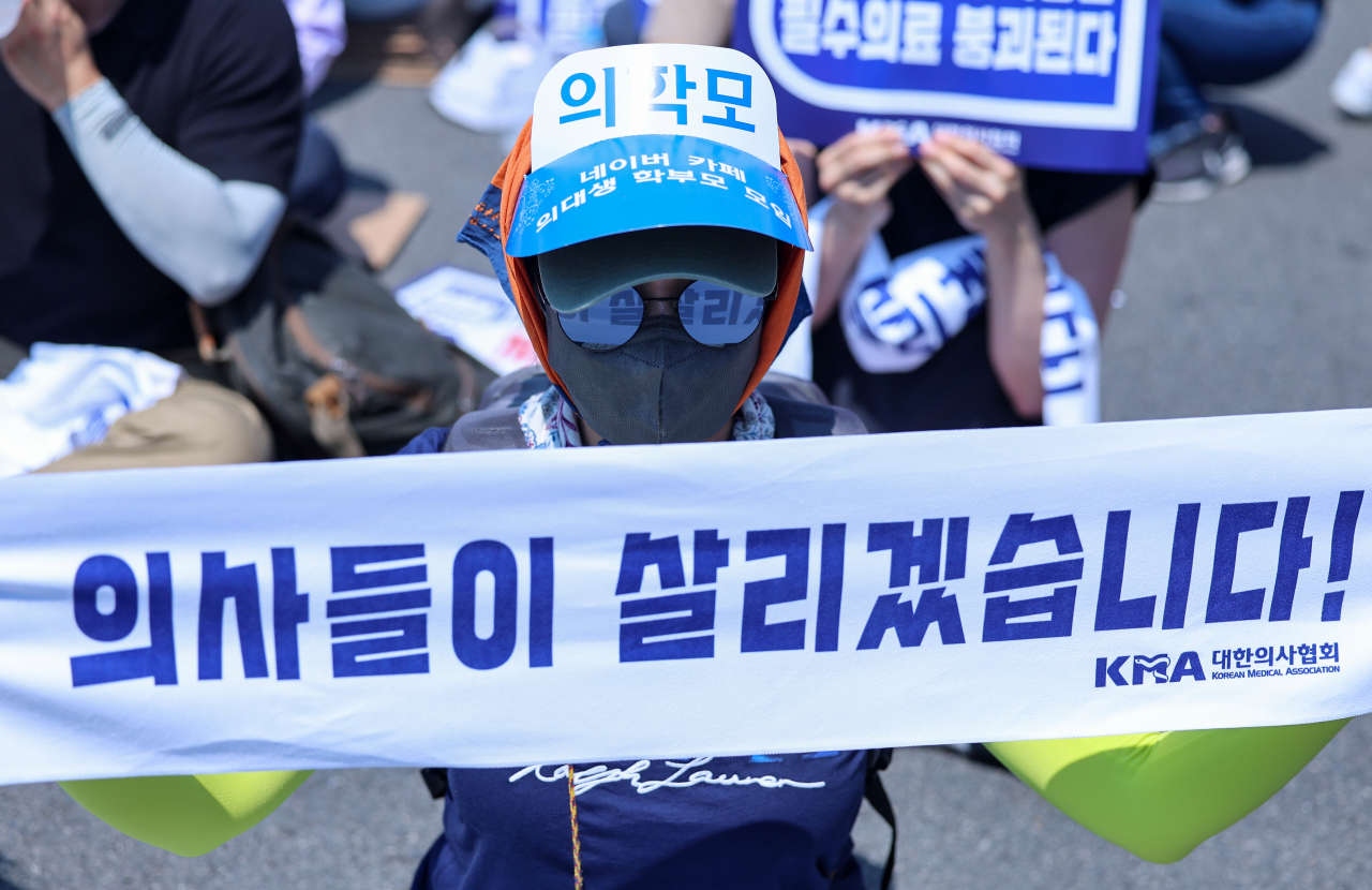 대한의사협회(의협)의 주도로 개원의와 일부 의대 교수들이 집단휴진에 나선 18일 오후 서울 영등포구 여의대로에서 열린 전국 의사 총궐기대회에서 의대생 학부모들이 현수막을 들고 있다. [연합]