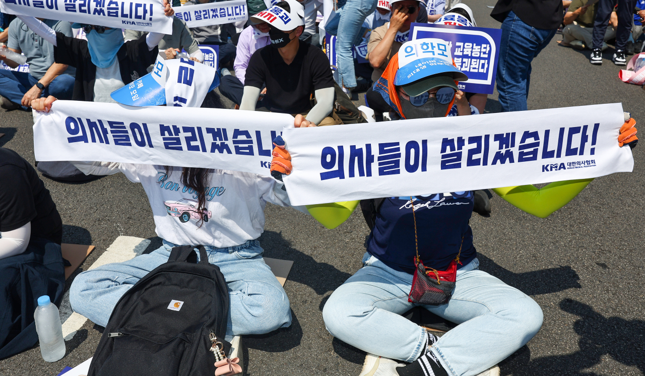 대한의사협회(의협)의 주도로 개원의와 일부 의대 교수들이 집단휴진에 나선 18일 오후 서울 영등포구 여의대로에서 열린 전국 의사 총궐기대회에서 의대생 학부모들이 현수막을 들고 있다. [연합]