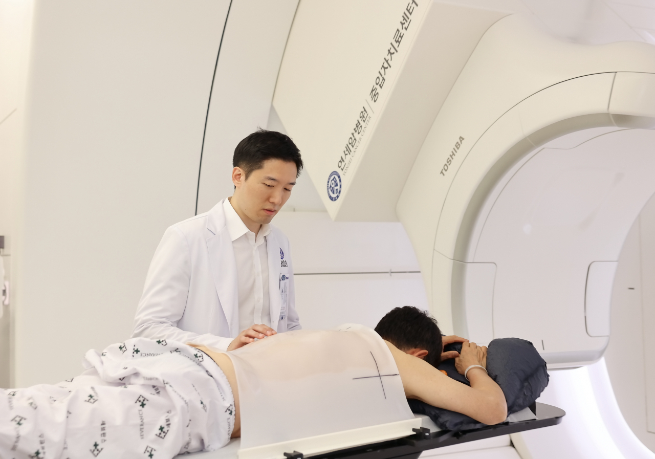 김경환 연세암병원 방사선종양학과 교수가 중입자치료 시작 전 환자를 살피고 있다. [연세암병원 제공]