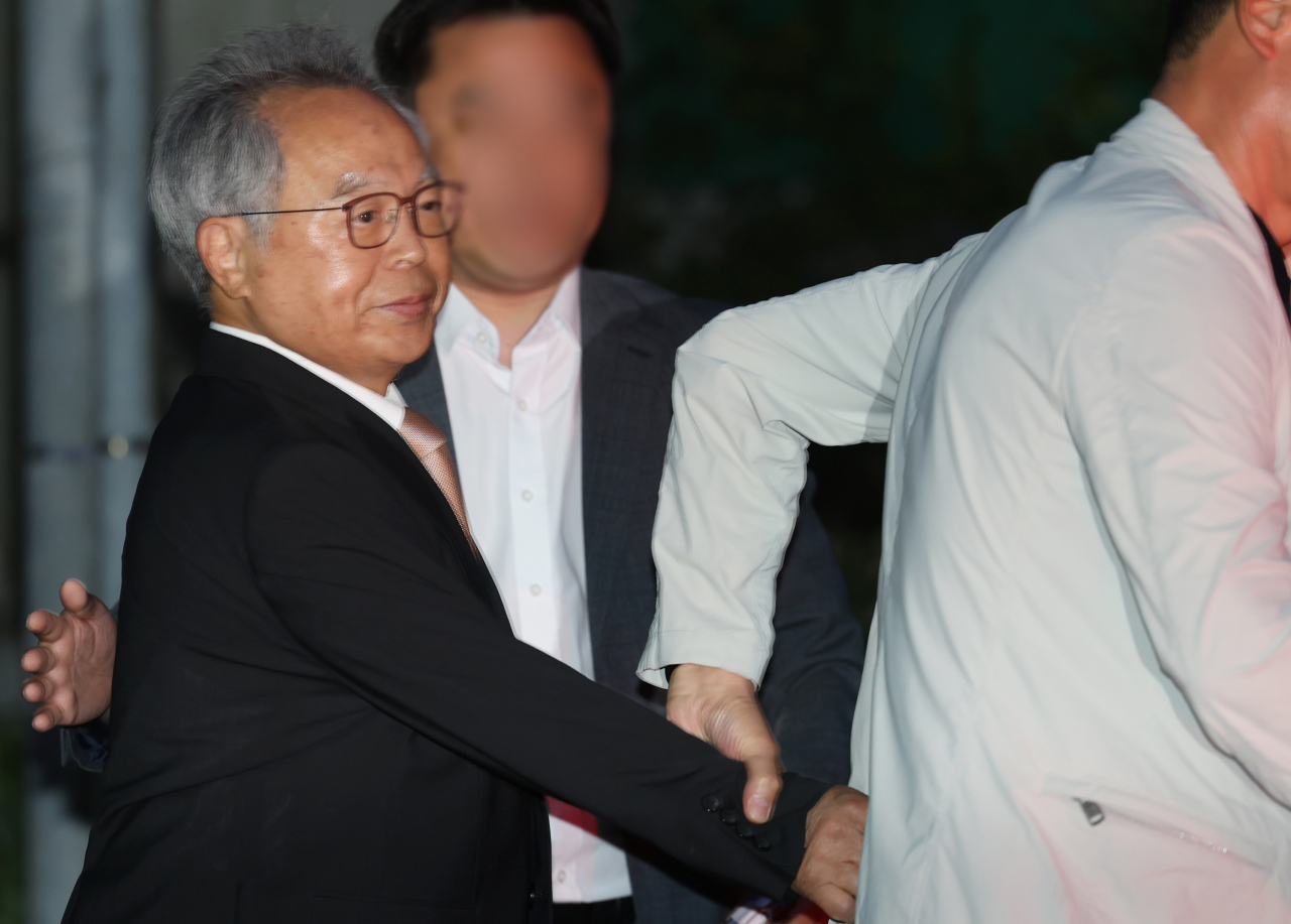 직원을 강제 추행한 혐의로 징역 3년을 선고받은 오거돈 전 부산시장이 26일 오전 만기 출소로 풀려나 부산 사상구 부산구치소를 나서고 있다. 취재진 질문이 이어지자 오 전 시장의 지인은 그의 손을 이끌고 차량에 빠르게 태웠다. [연합]