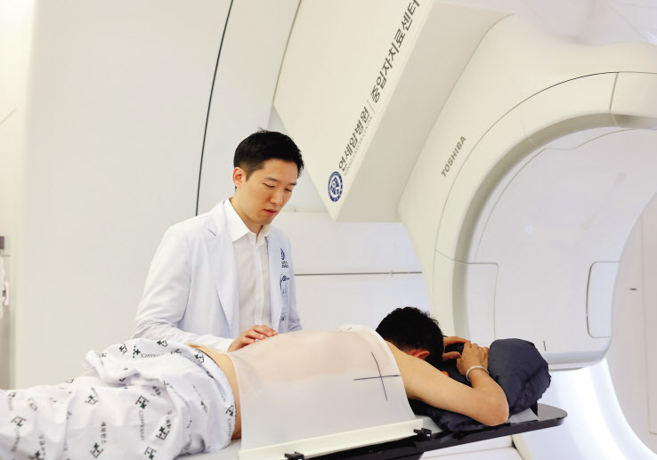 김경환 연세암병원 방사선종양학과 교수가 중입자치료 시작 전 환자를 살피고 있다. [연세암병원 제공]
