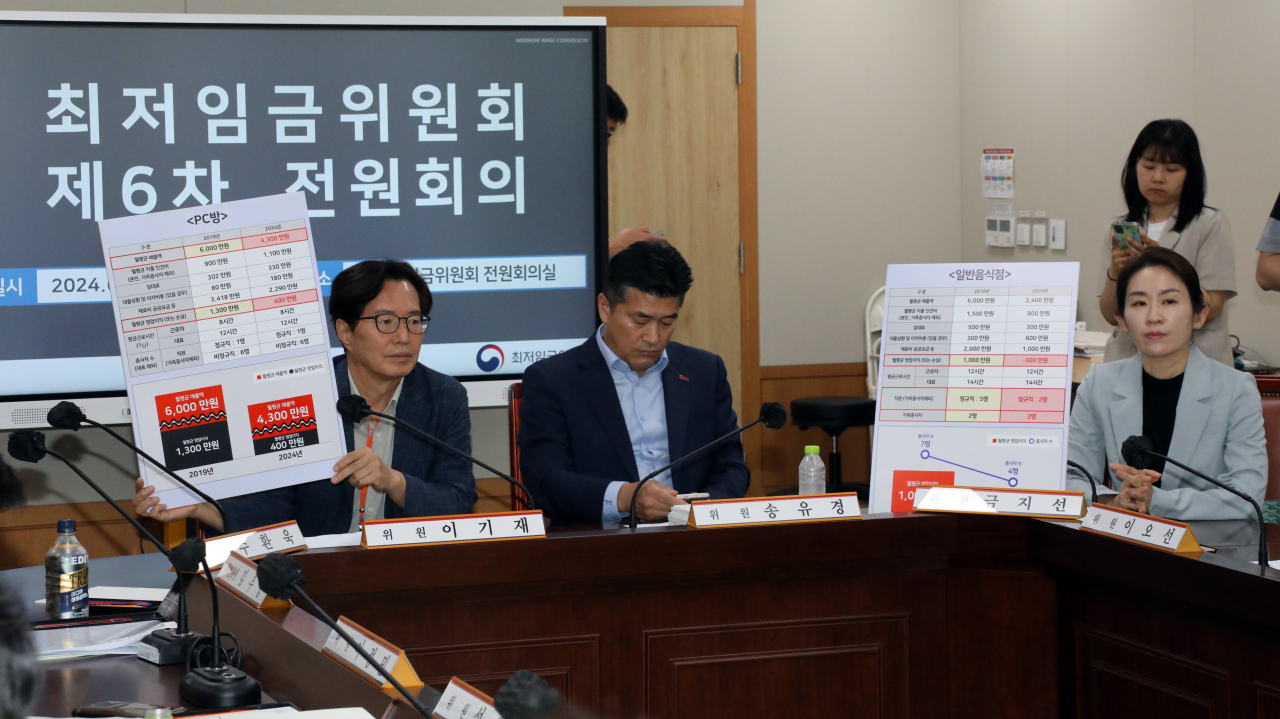 최저임금 법정 심의 기한인 27일 오후 정부세종청사 최저임금위원회 회의실에서 열린 제6차 전원회의에서 사용자위원인 이기재 소상공인연합회 부회장(왼쪽)과 금지선 한국메이크업미용사회 회장(오른쪽)이 PC방과 일반음식점의 2019년과 2024년 월평균 매출액 및 영업이익(손실)이 담긴 표를 보여주고 있다. [연합]