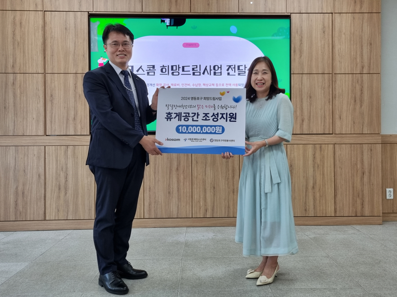 황상검(왼쪽) 코스콤 부서장이 서울 영등포구 시립문래청소년센터에서 열린 ‘영등포구 발달장애 청소년을 위한 휴게 공간 개소식’에 참석해 조미란 문래청소년센터 관장에게 기부금 전달식을 진행하고 기념 촬영을 찍고 있다. [코스콤]