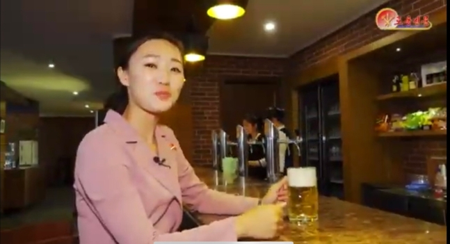 북한 림흥거리에 새로 생긴 대동강맥주집을 찾은 북한 기자. [노동신문]