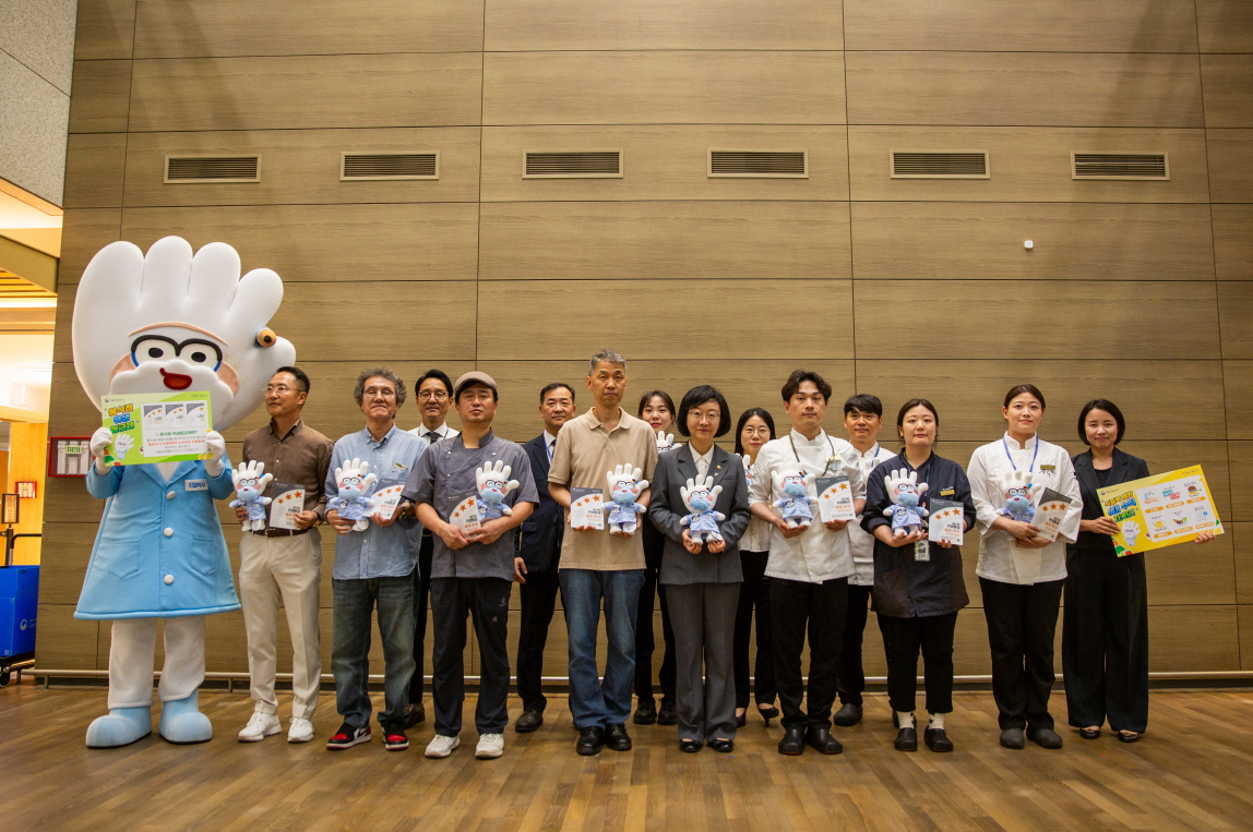 지난 27일 아워홈 한식소담길 인천공항 제1터미널점에서 진행된 위생등급제 ‘매우 우수’ 획득 기념 현판식에서 오유경 식약처장(앞줄 가운데)과 직원들이 기념 촬영을 진행하고 있다. [아워홈 제공]
