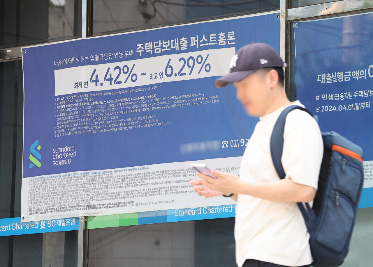 서울 한 시중은행 영업점의 대출 안내문 앞을 시민이 지나가고 있다.[연합]