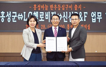 지난달 28일 홍성군청에서 진행된 업무협약식에서 강명신(왼쪽부터) LG헬로비전 미디어그룹장, 이용록 홍성군수, 유형진 신선P&F 대표가 기념촬영을 하고 있다.